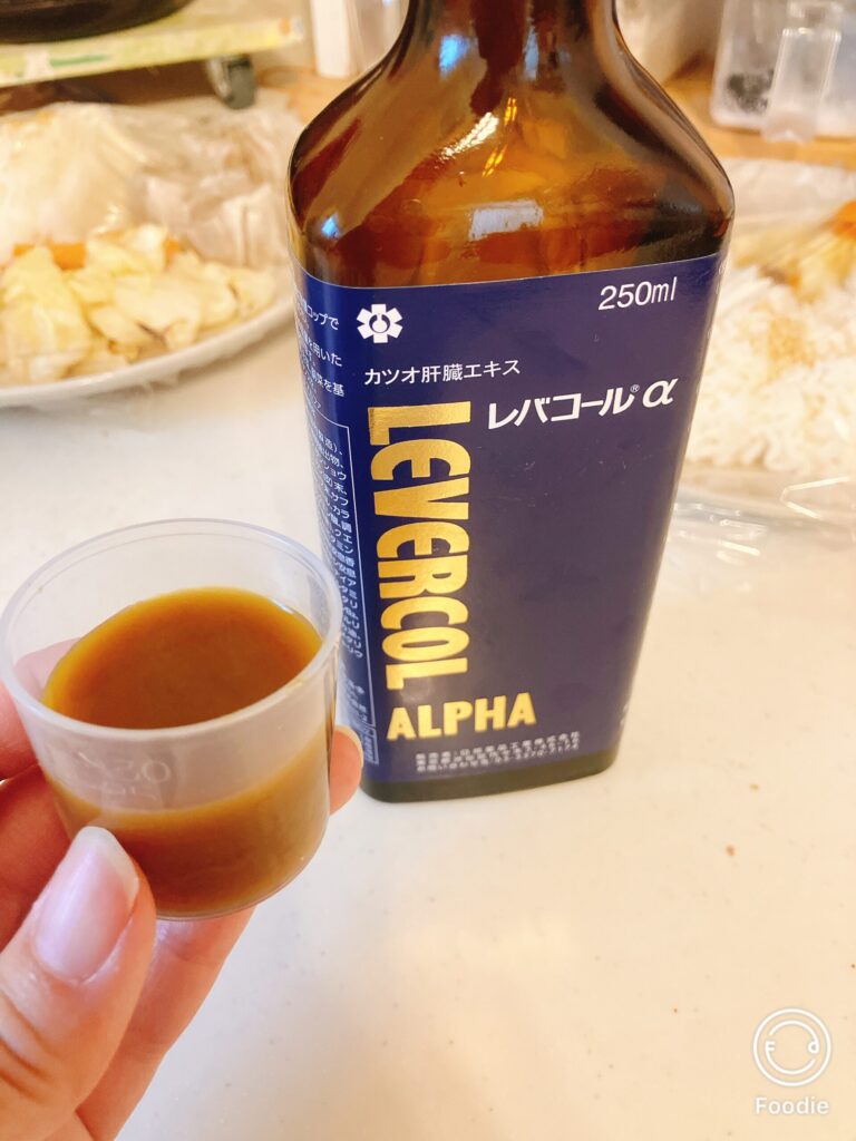 レバコールαのボトルと計量カップに注がれた液体