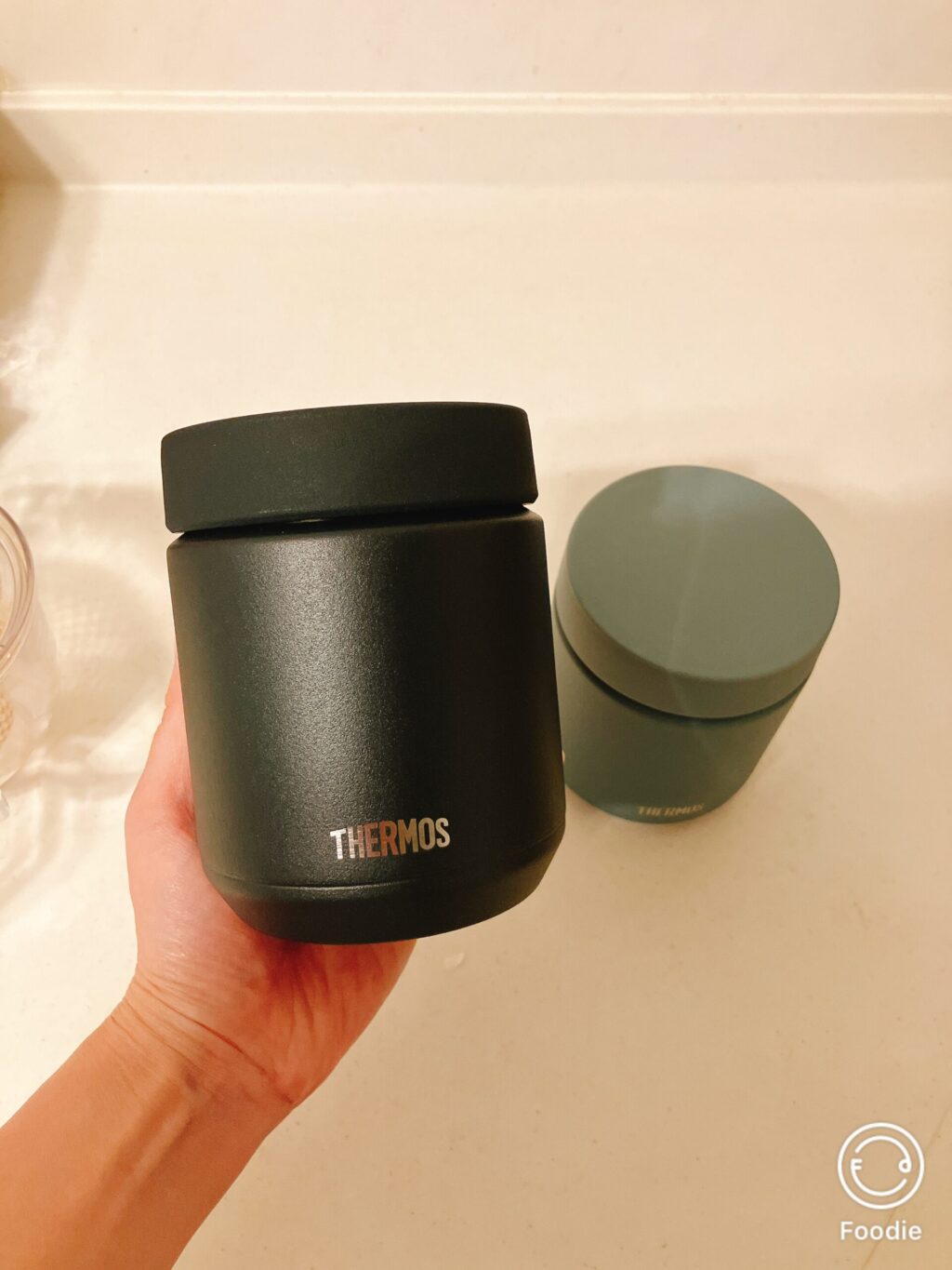 黒のサーモススープジャーを手に持ってサイズ感を確認している様子